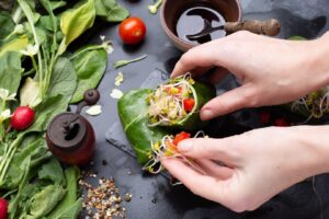 chef-making-vegan-wrap-with-red-peppers-tomatoes_181624-45389 (1)